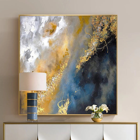 Abstract art piece with gold and blue tones on a wall above a console table.