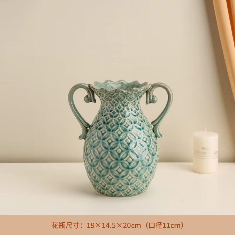 Decorative ceramic vase with geometric pattern on a beige surface with a candle.