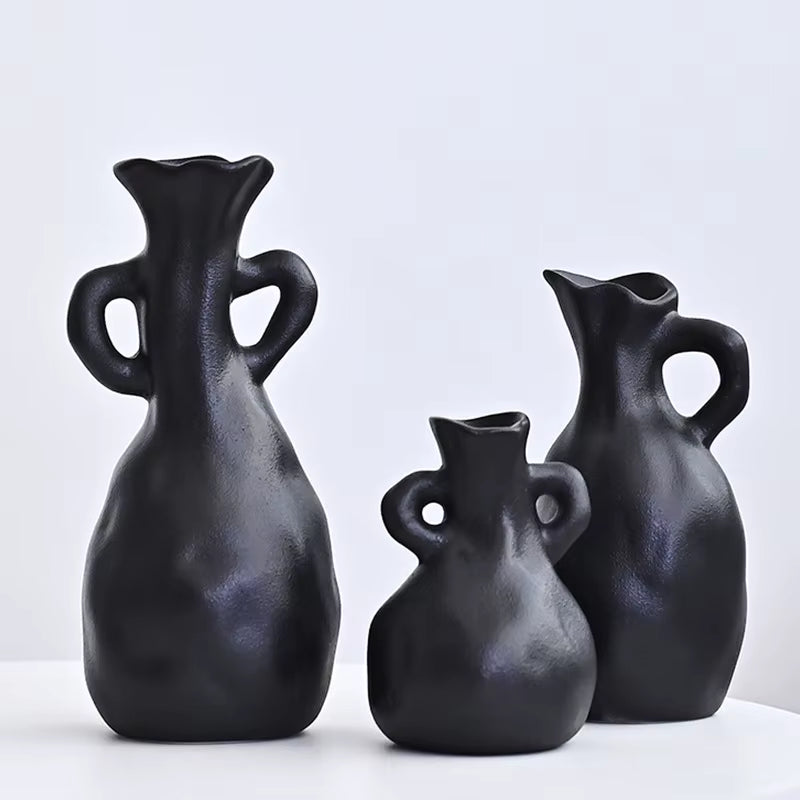 Three black ceramic vases of different shapes on a white background