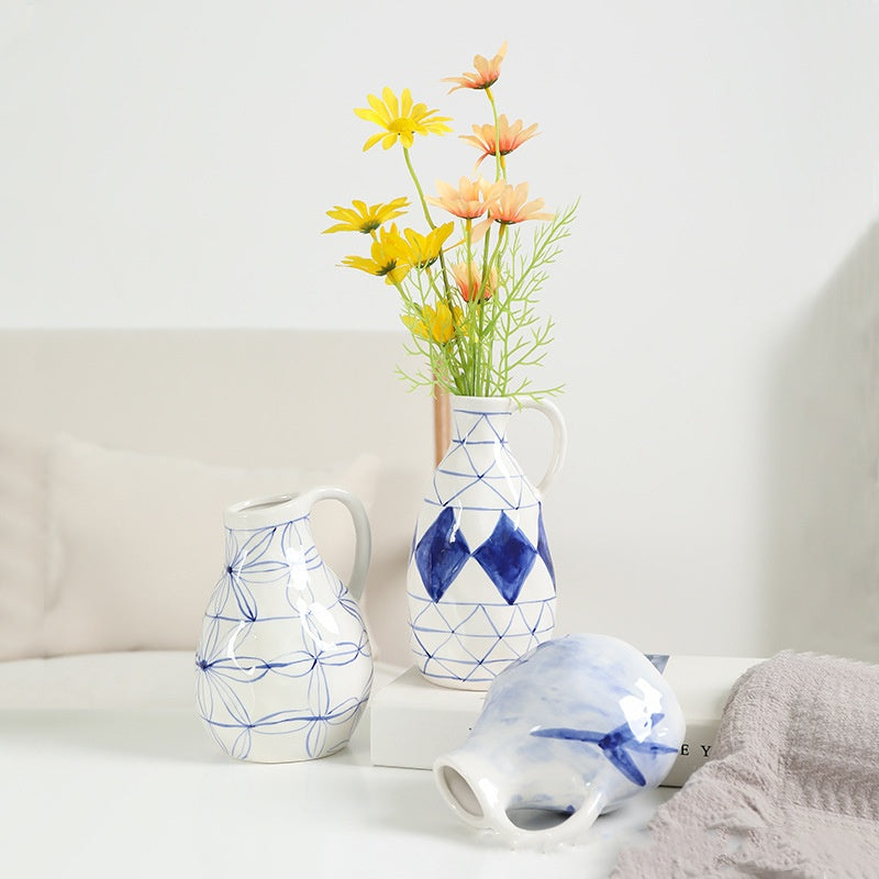 Three ceramic vases with geometric patterns on a white surface.