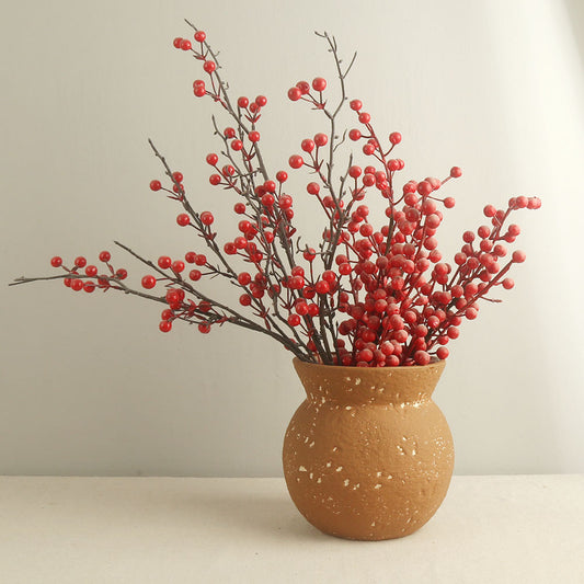 Vase with red berries on a plain background