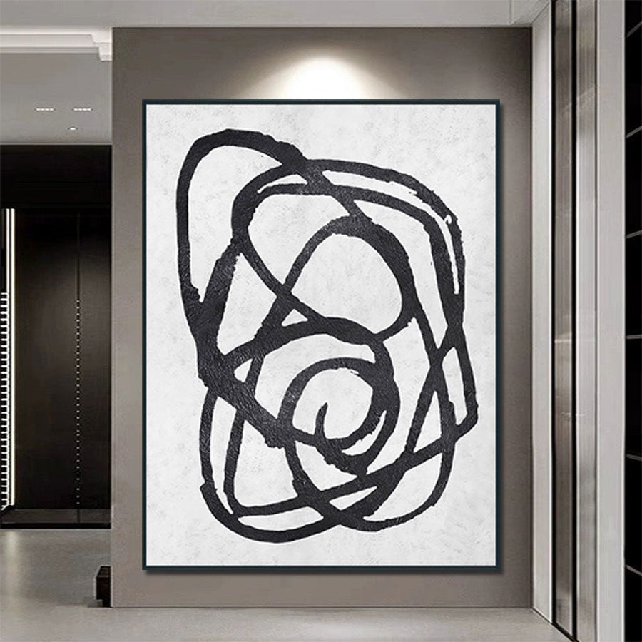 Abstract black artwork on a textured white background in a modern interior setting.