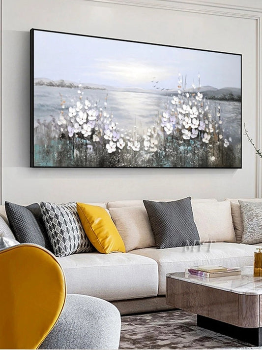 Living room with a large abstract painting on the wall above a white sofa with colorful cushions.