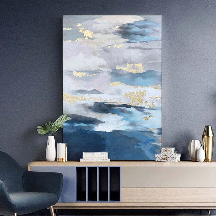 Abstract painting of a landscape with clouds on a wall above a console table.