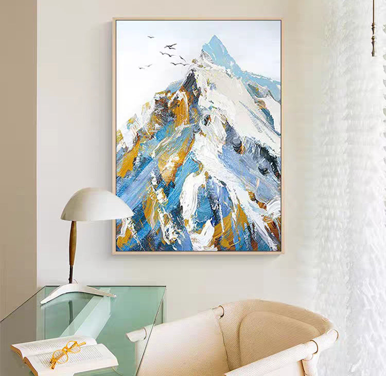 Abstract painting of a mountain scene in a modern interior setting with a chair and lamp.