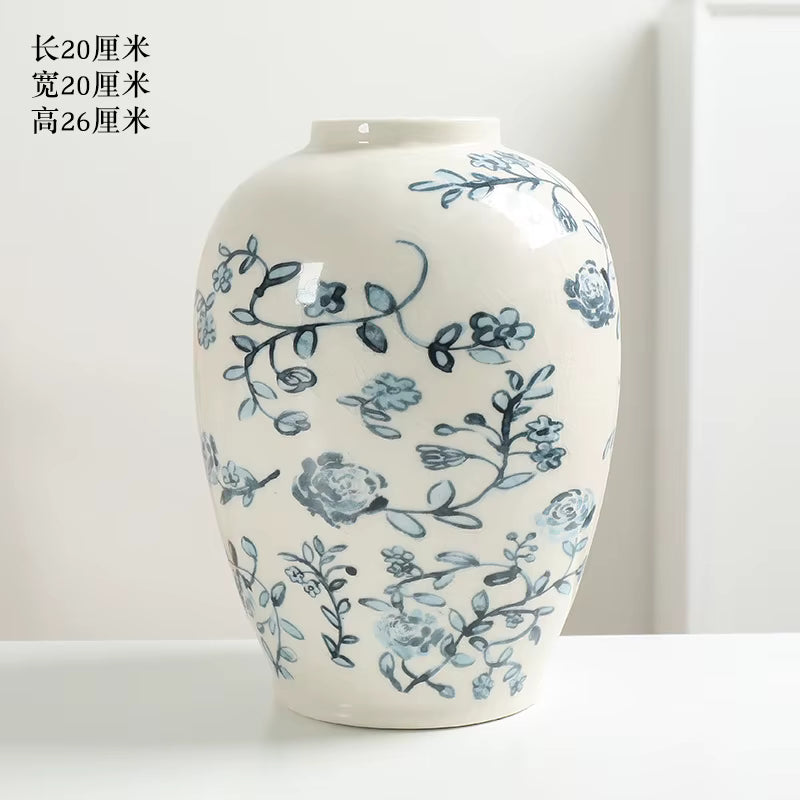 White ceramic vase with blue floral patterns on a white background