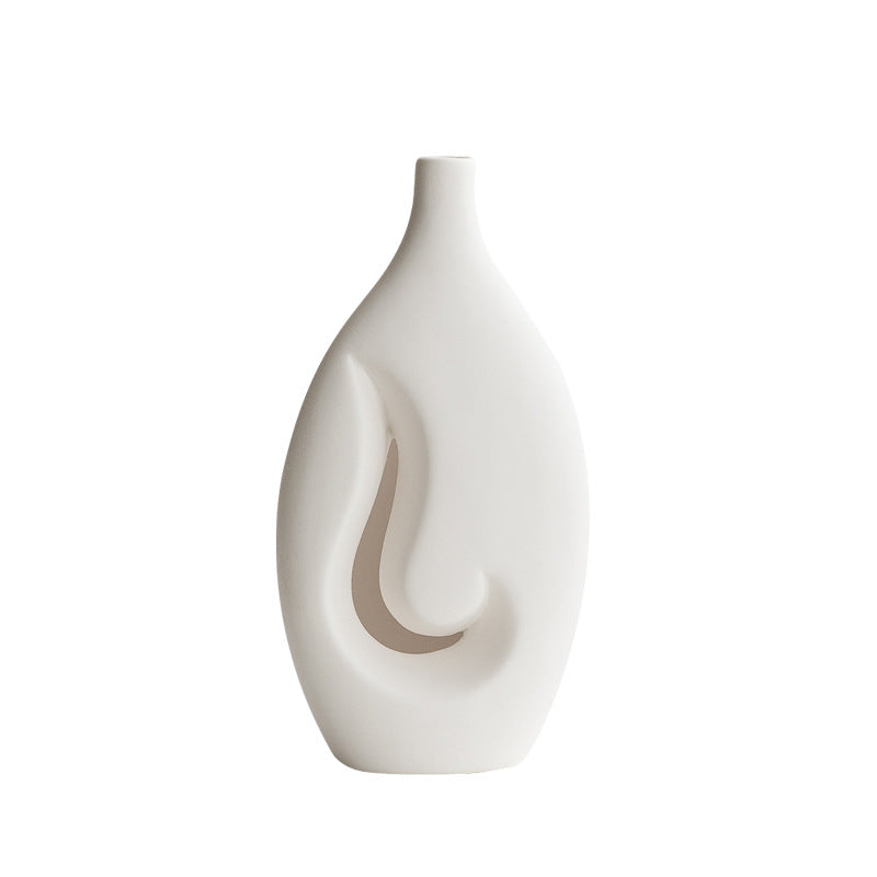 White ceramic vase with abstract design on a white background