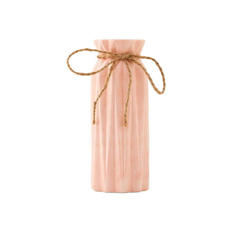 Pink bottle with a string bow on a white background