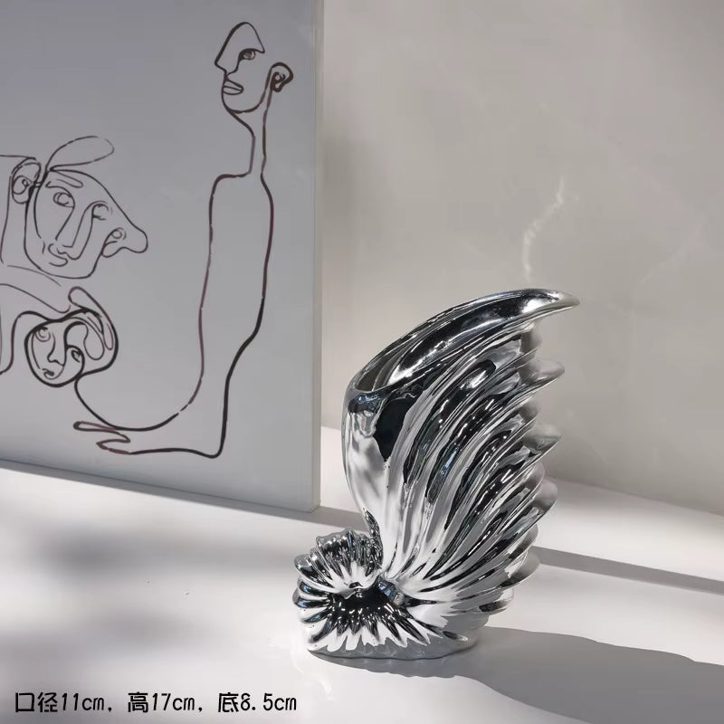 Decorative glass sculpture on a white surface with abstract art in the background
