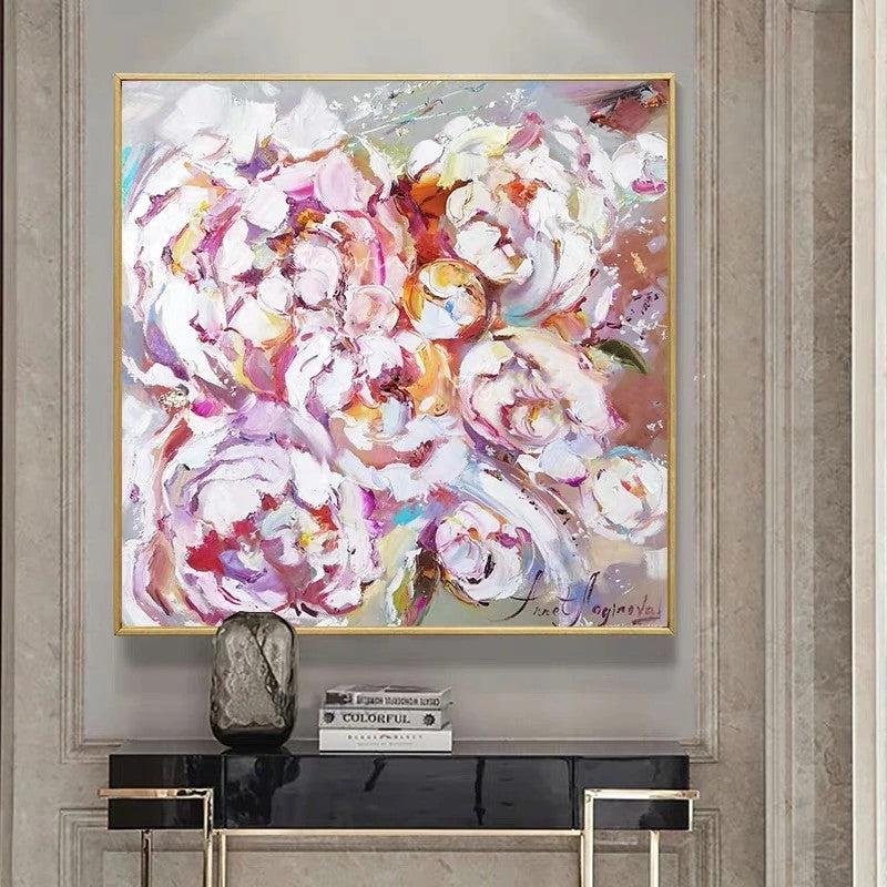 Abstract floral painting in a gold frame on a wall above a console table.