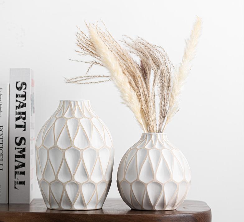 Two decorative vases with geometric patterns on a wooden surface.