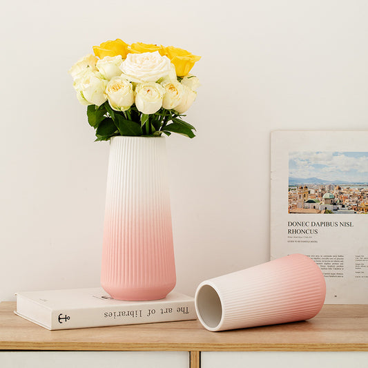 Gradient pink and white vase with flowers on a wooden surface