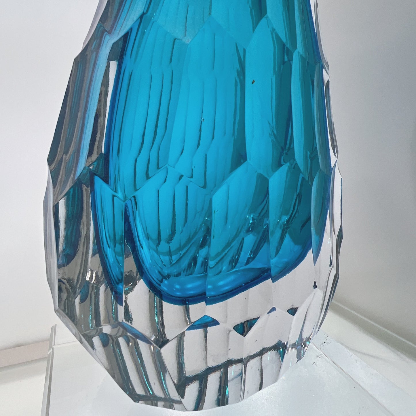 Blue and clear geometric glass vase on a white background