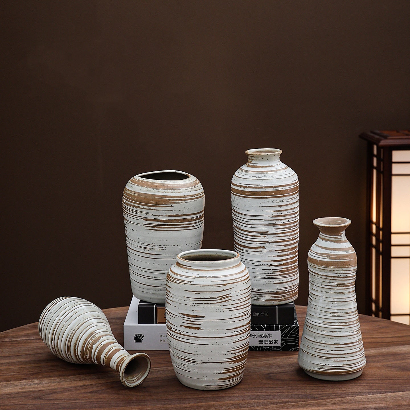 Set of ceramic vases with striped design on a wooden surface against a dark background