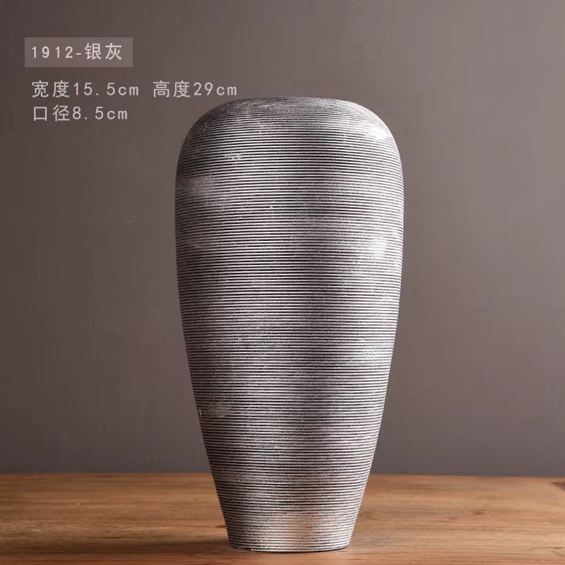 Decorative vase with textured surface on a wooden table against a dark background