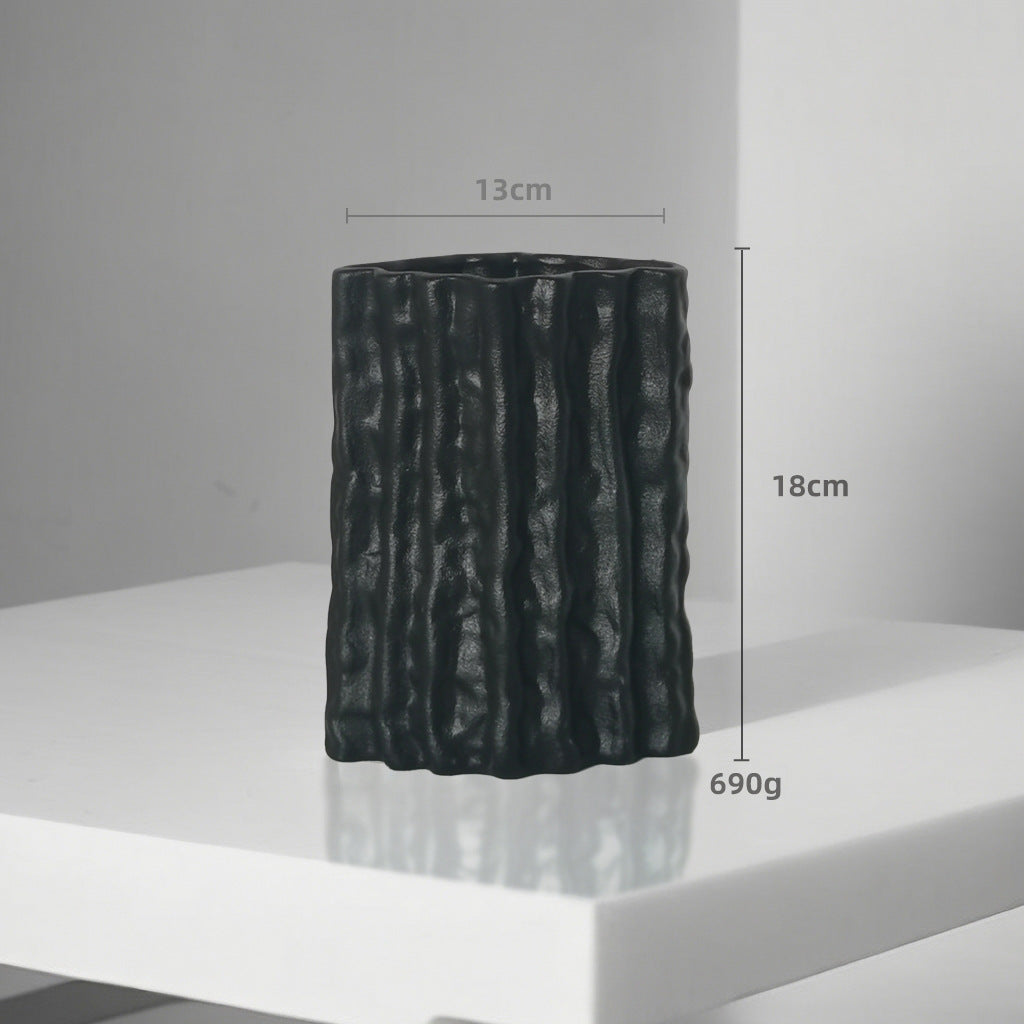 Black textured vase on a white surface with measurements indicated