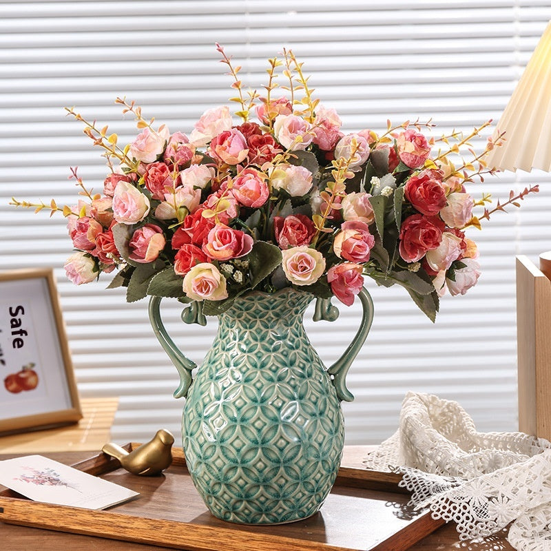 Decorative vase with pink flowers on a wooden surface