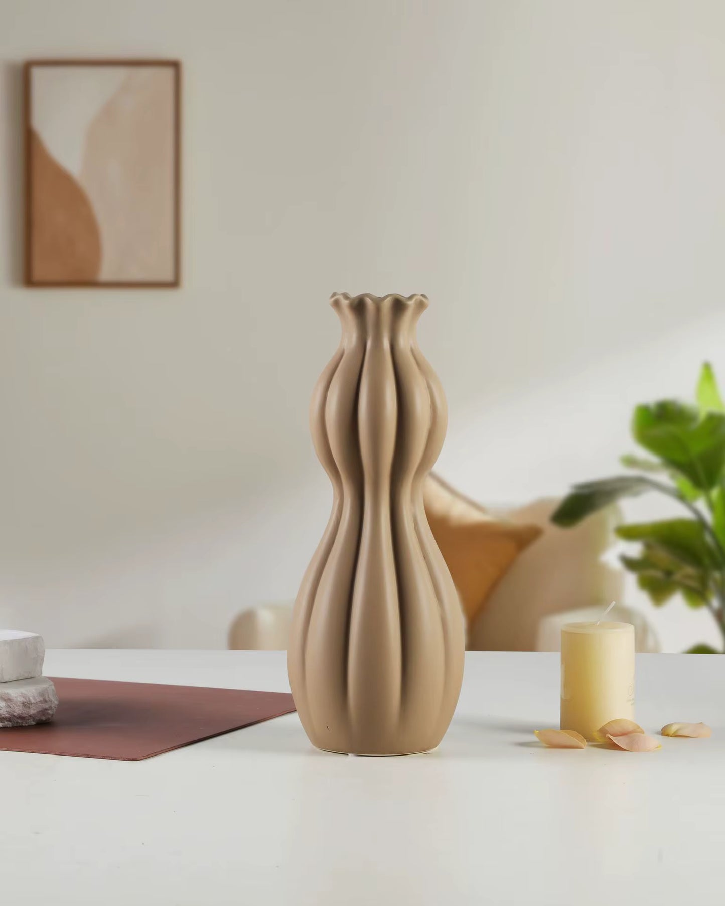 Beige ceramic vase on a white surface with a blurred background