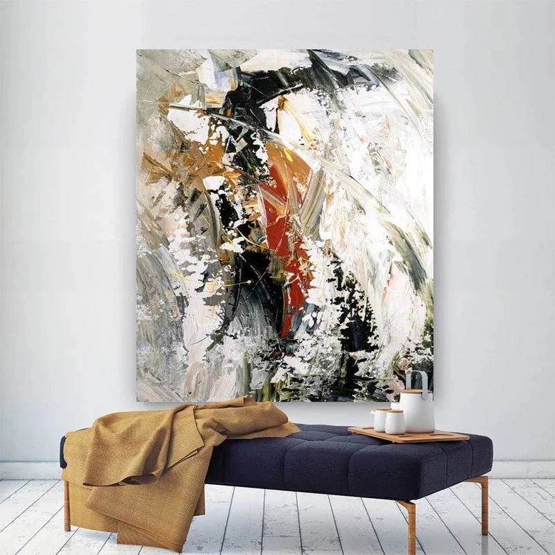 Abstract painting on a white wall above a bench with a blanket and small table.