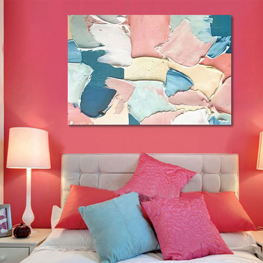 Bedroom with abstract art on the wall, colorful pillows, and a lamp.