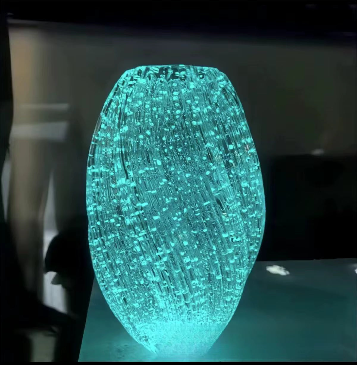 Glowing blue fiber optic light on a reflective surface