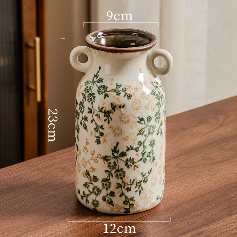 Ceramic vase with floral patterns on a wooden surface, showing dimensions.