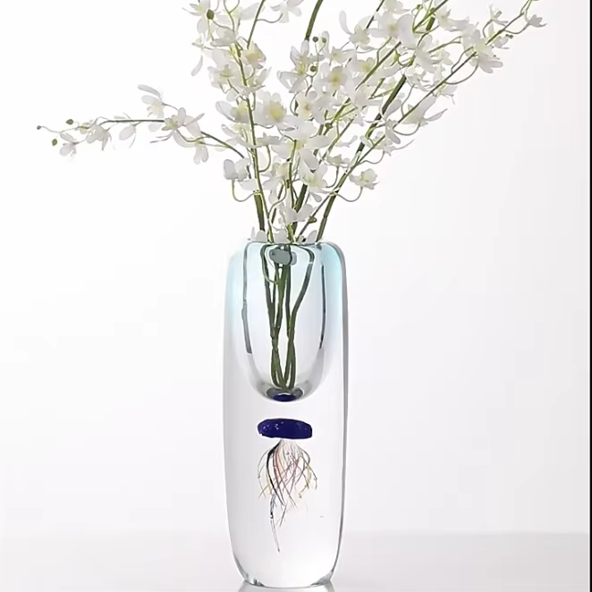 Clear glass vase with a jellyfish design and white flowers on a white background