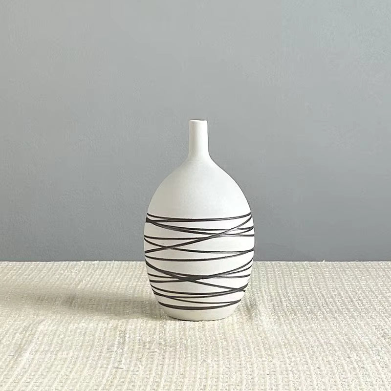 White vase with black abstract patterns on a gray surface
