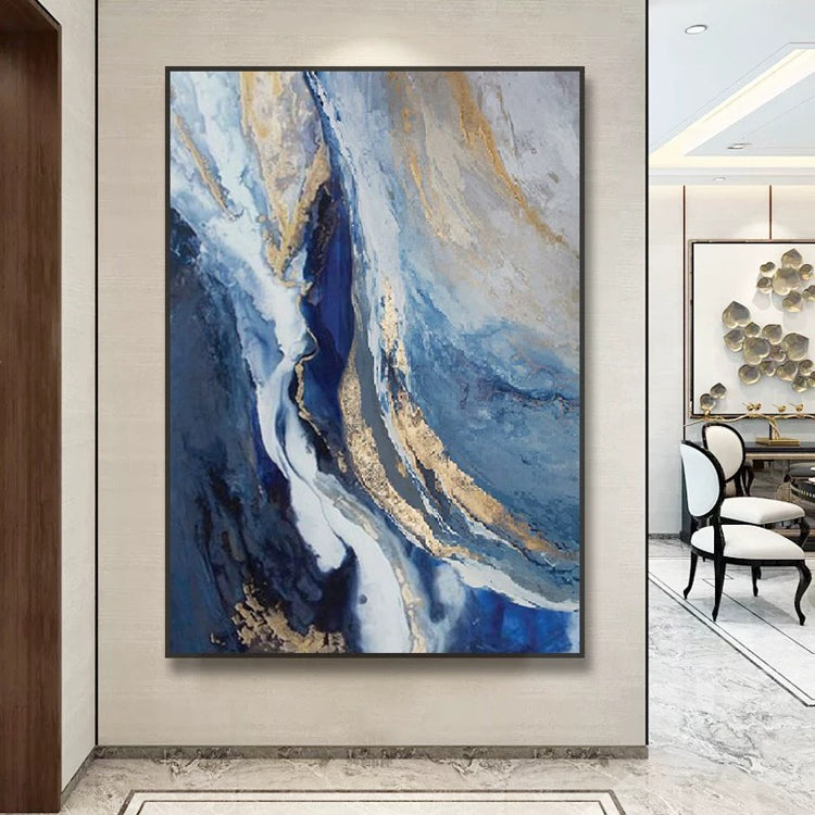 Abstract painting with blue and gold tones on a wall in a modern interior setting.