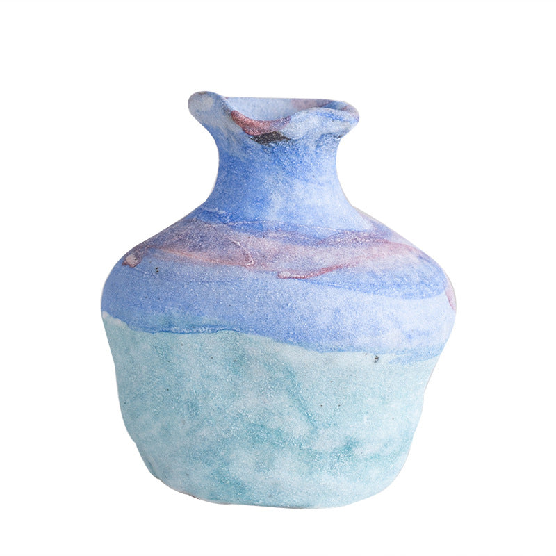 Ceramic vase with blue and pink marbled pattern on a white background