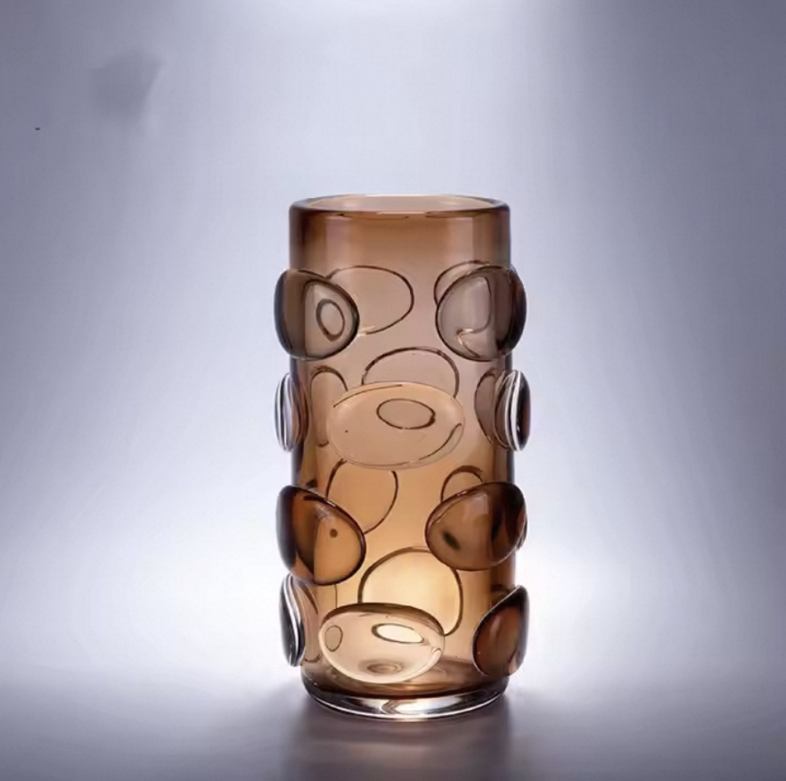 Brown glass vase with circular patterns on a gray background