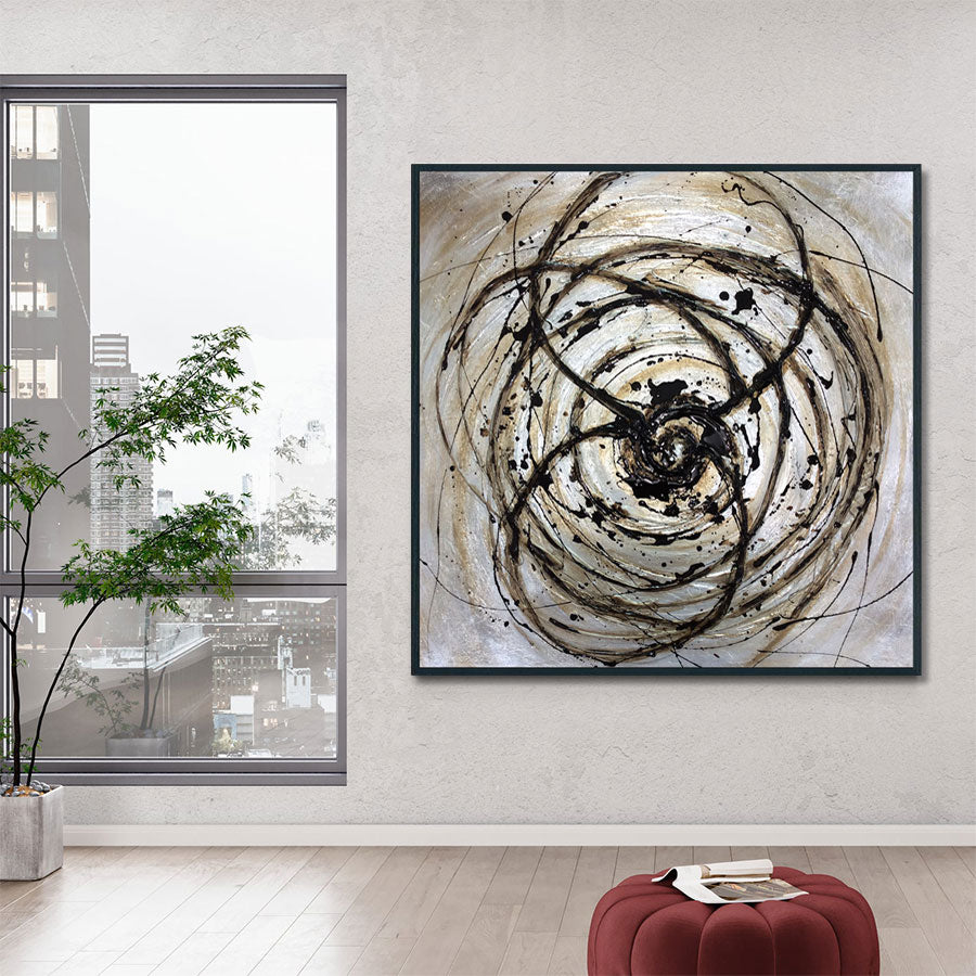 Abstract art piece on a wall with a cityscape view through a window.