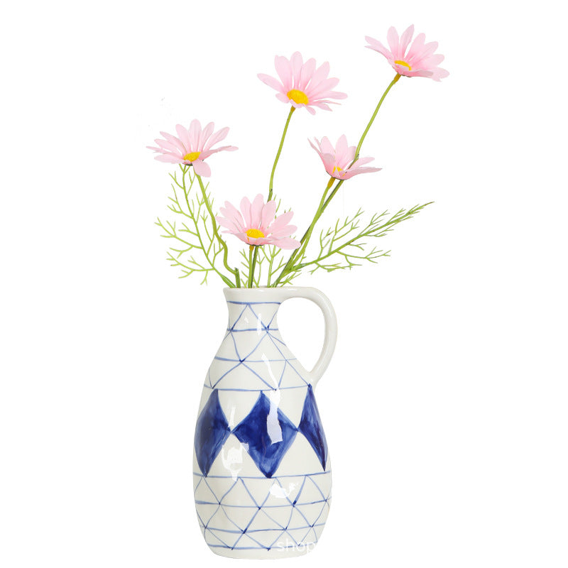 Vase with geometric design and pink flowers on a white background