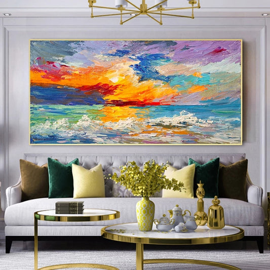 Living room with a large abstract painting of a sunset, white sofa with colorful pillows, and decorative items on tables.