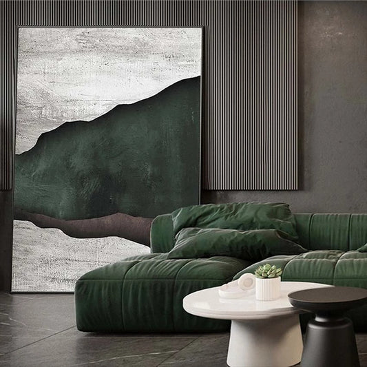 Modern living room with green sofa, abstract art, and a small table with decor items.