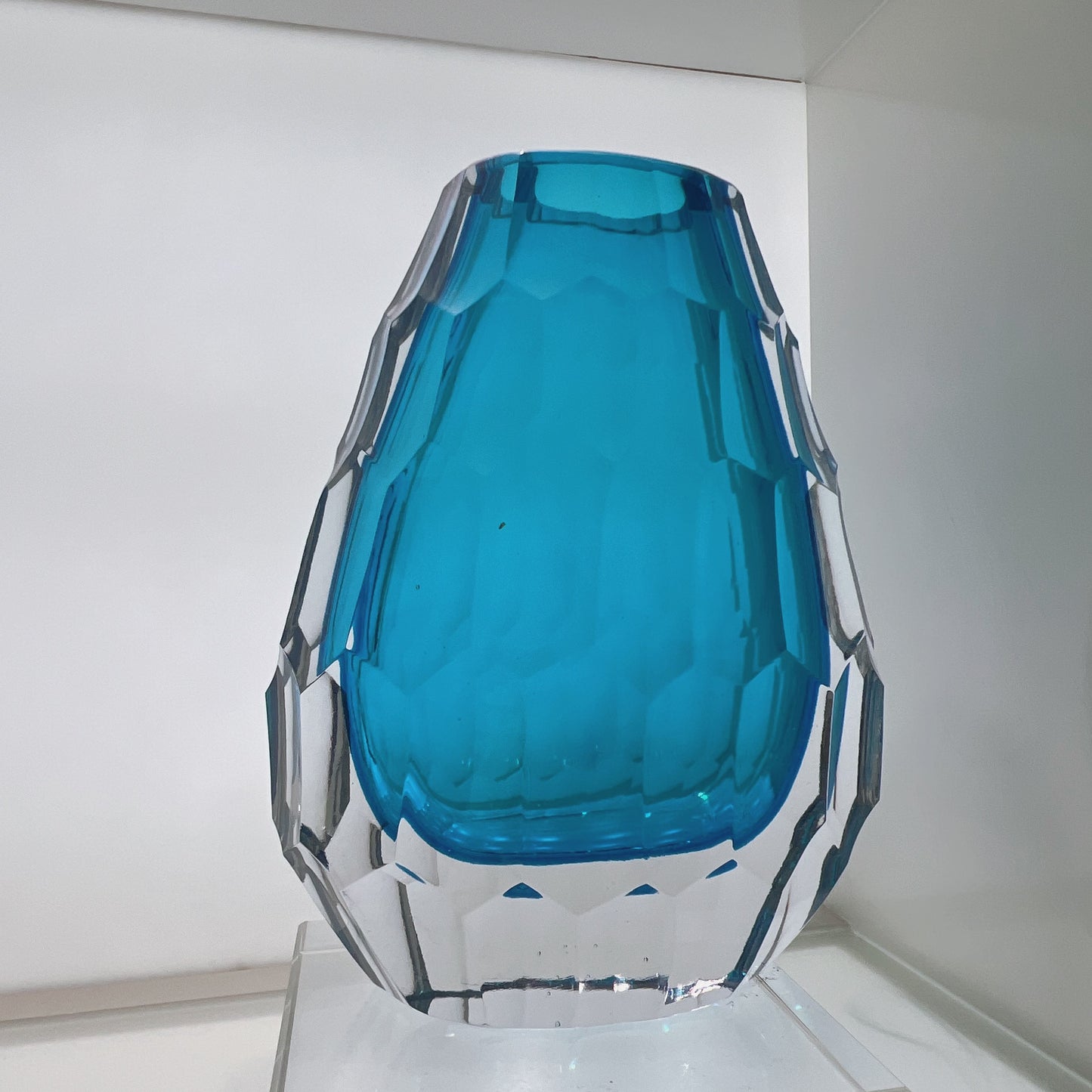 Blue glass vase with geometric design on a white background