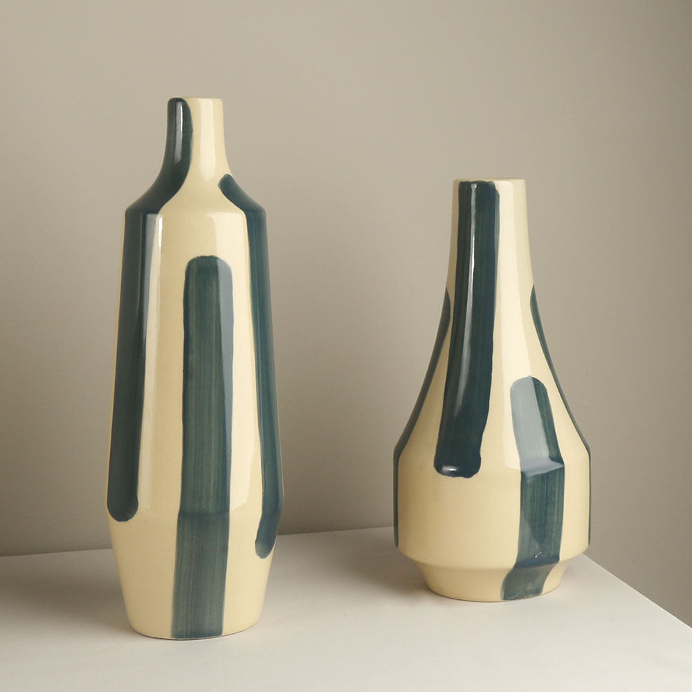 Two ceramic vases with green accents on a neutral background