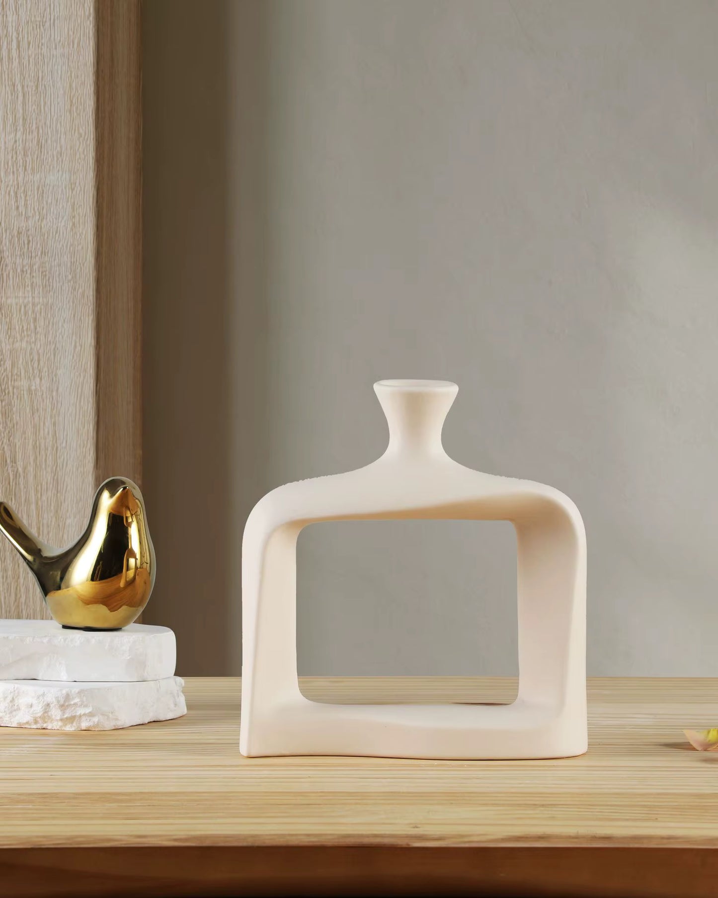 Modern ceramic vase on a wooden surface with a neutral background