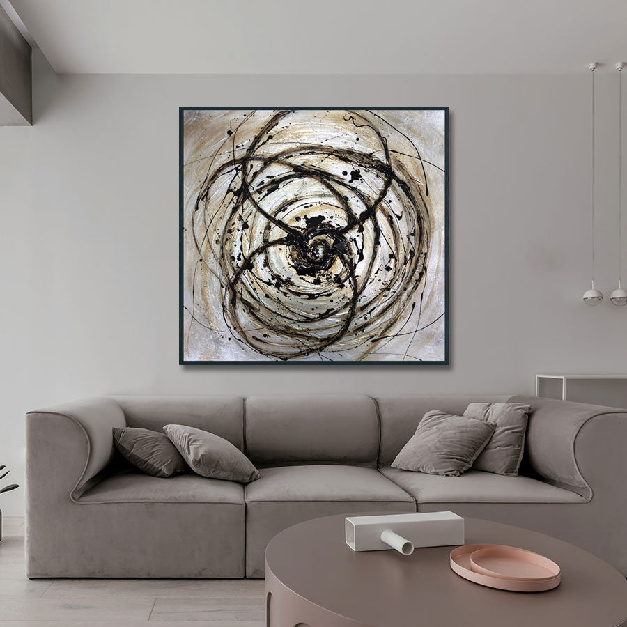 Abstract art piece on a wall above a gray sofa in a modern living room.