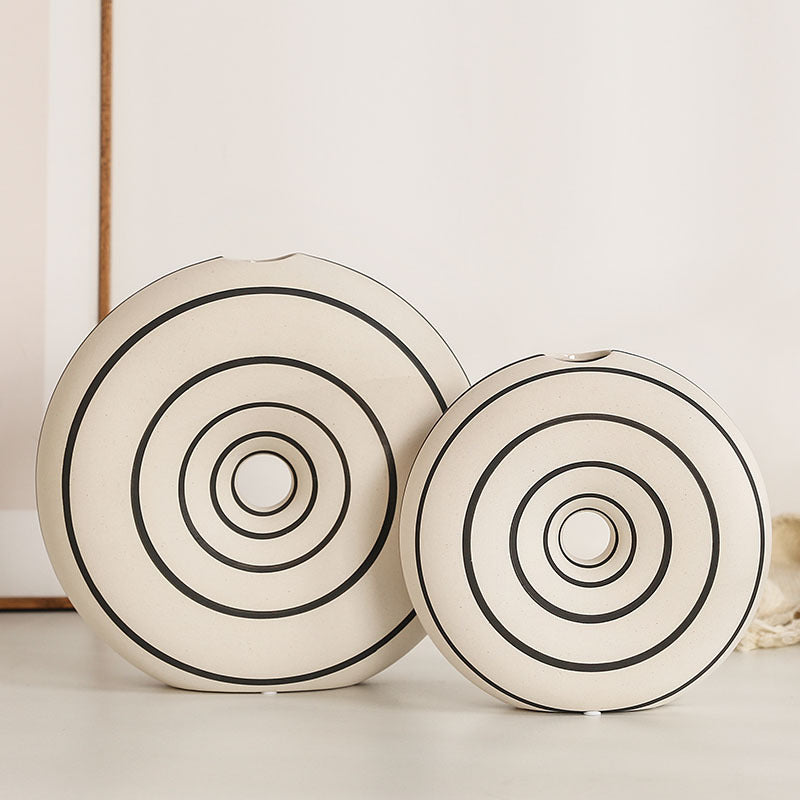 Two decorative plates with concentric circle patterns on a light background