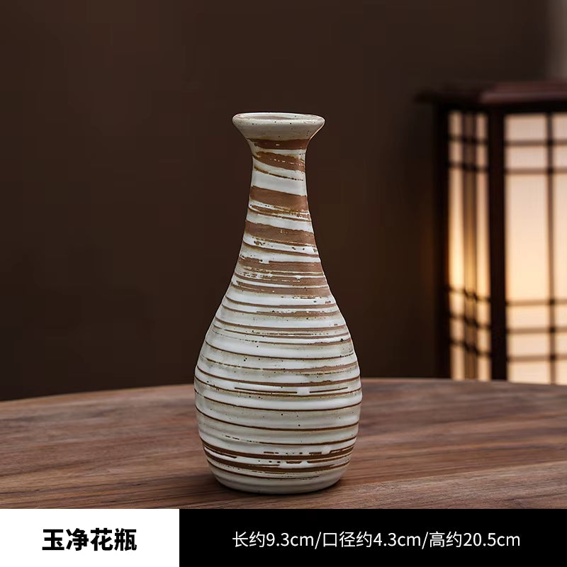 Ceramic vase with striped design on a wooden surface