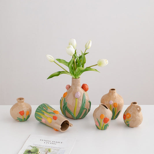 Set of small ceramic vases with floral designs on a light gray background