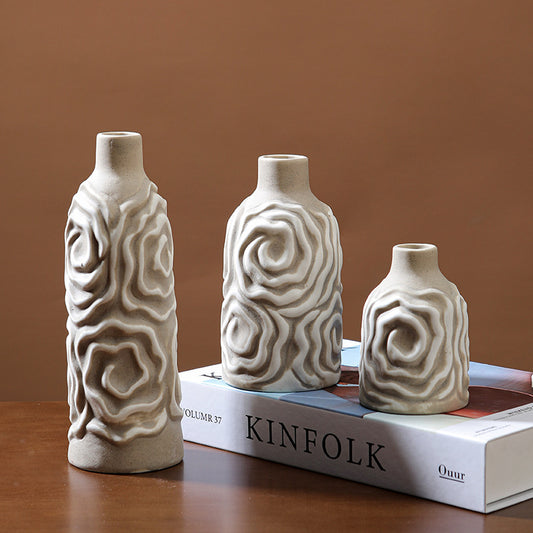 Three ceramic vases with textured designs on a book with 'KINFOLK' branding.