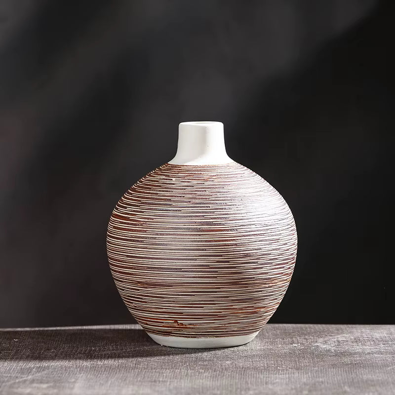 Decorative vase with brown and white striped pattern on a dark background