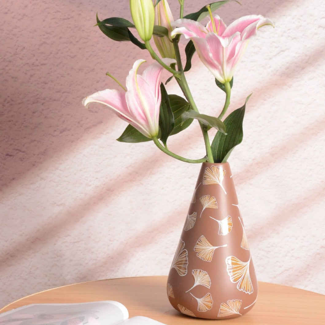 Decorative vase with floral design on a soft pink background