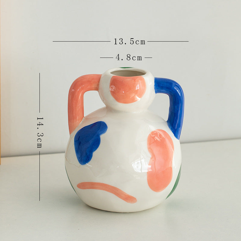 Ceramic vase with colorful abstract design and measurements on a white background