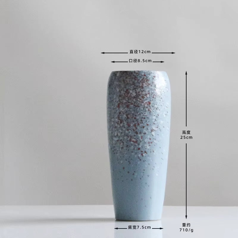 Blue speckled vase with measurements on a gray background