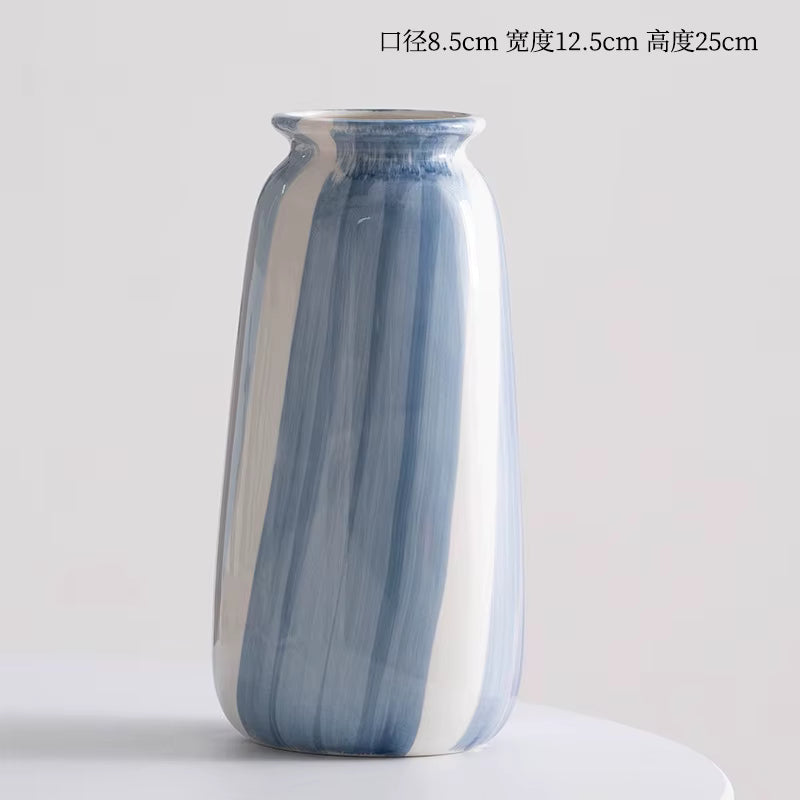 Blue and white striped ceramic vase on a light gray background