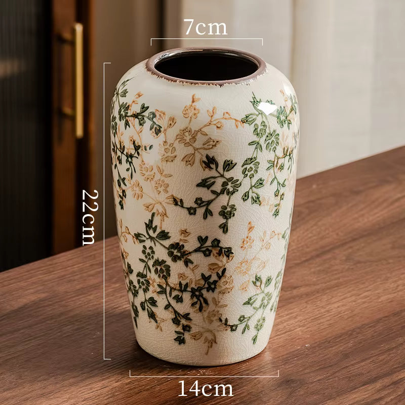 Decorative vase with floral patterns on a wooden surface, showing dimensions.