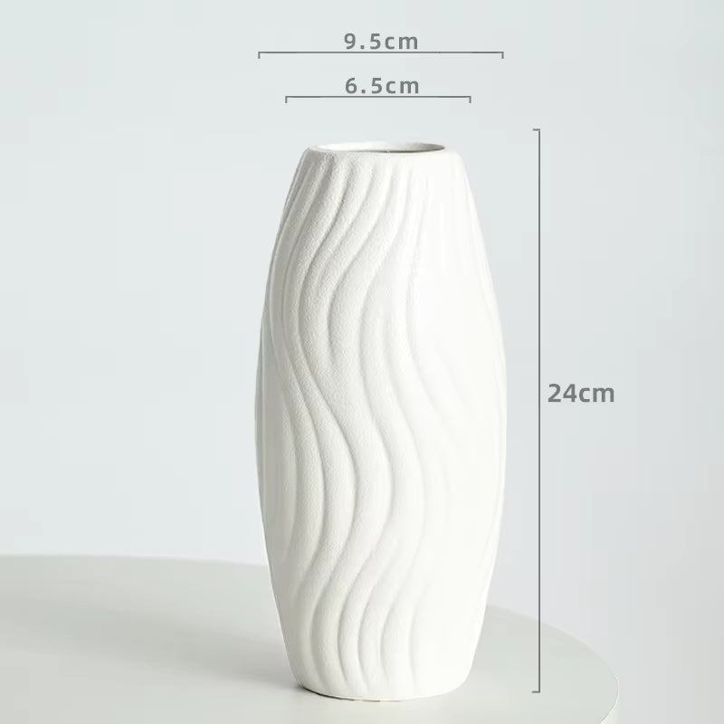 White ceramic vase with wavy design and dimensions on a light gray background